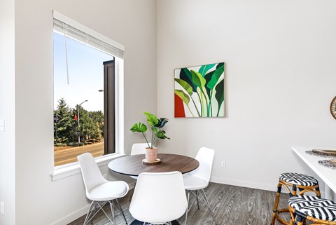 a dining room with a table and chairs and a large window