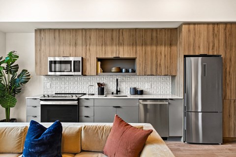 a kitchen with stainless steel appliances and a living room with a couch