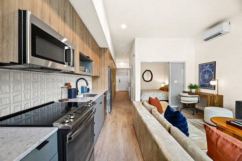 a kitchen with a stove top oven next to a living room