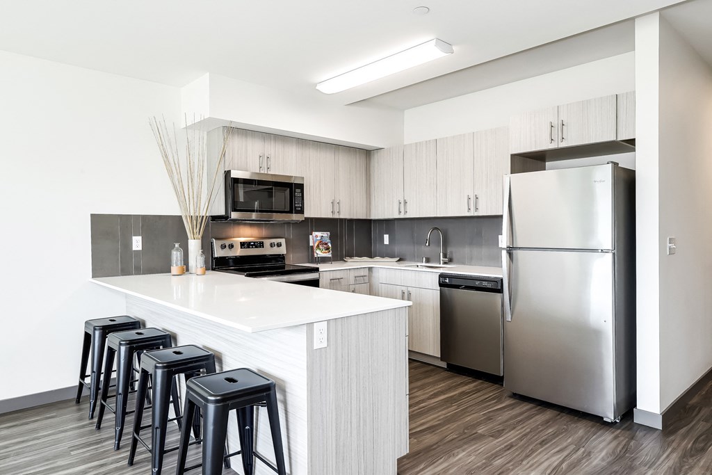 a kitchen with a large island and stainless steel appliances
