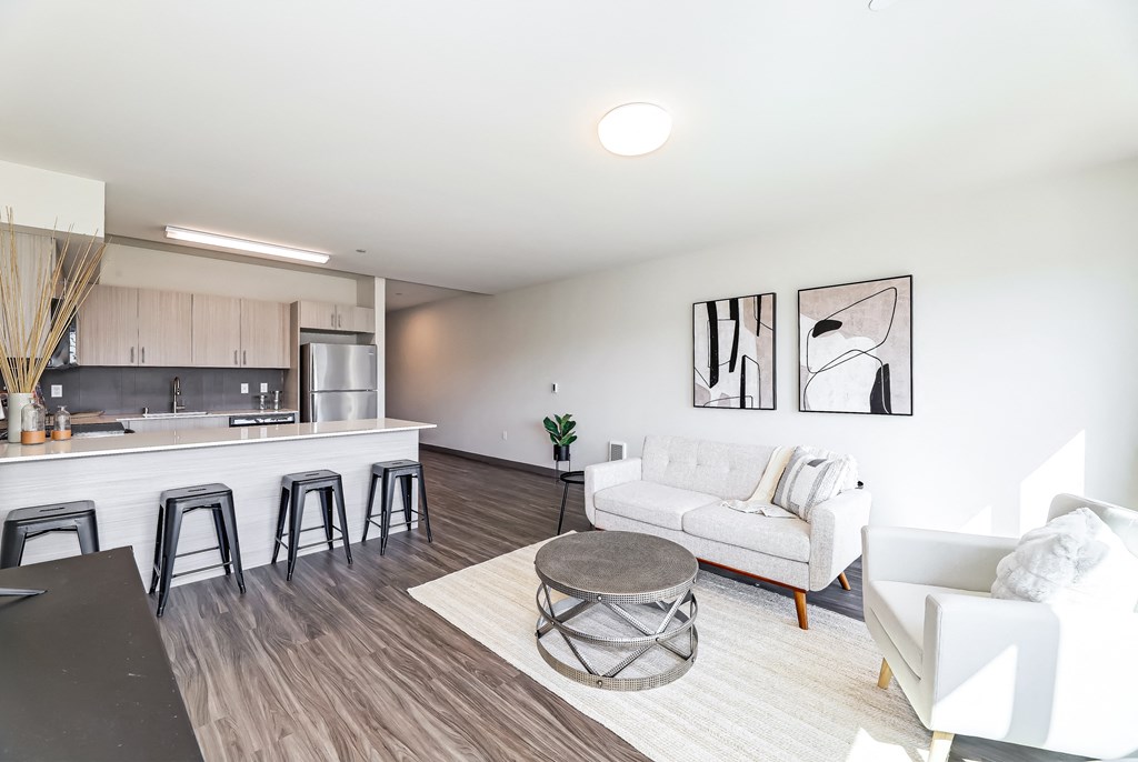 a living room with a couch and a kitchen with a bar