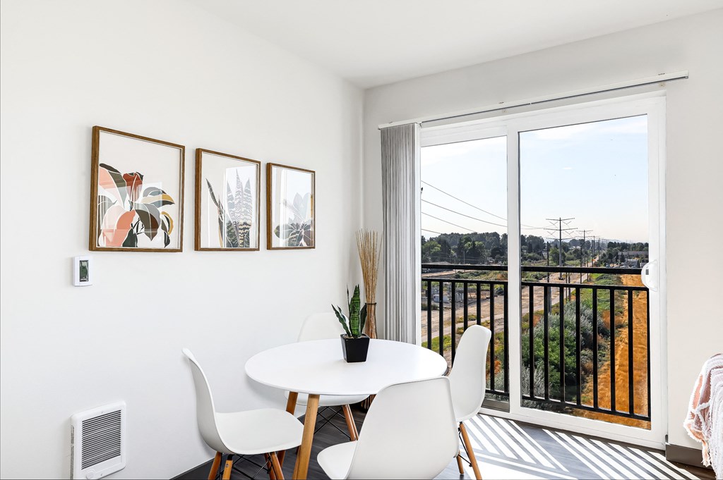 a dining room with a table and chairs and a balcony