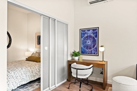 a bedroom with a bed and a desk with a chair