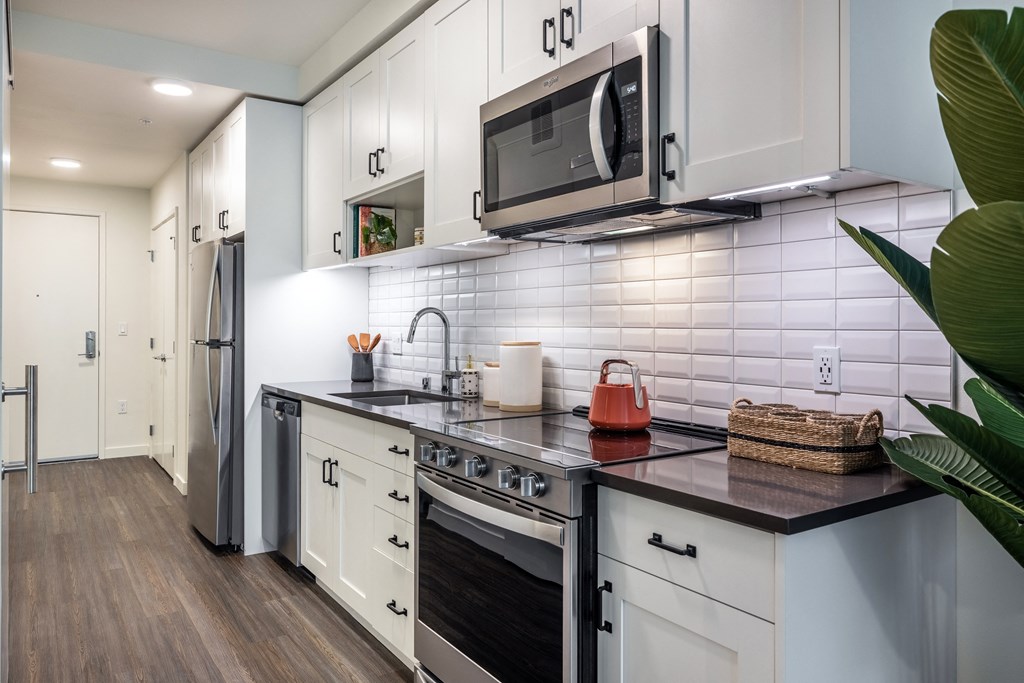 a kitchen with white cabinets and a stainless steel stove
