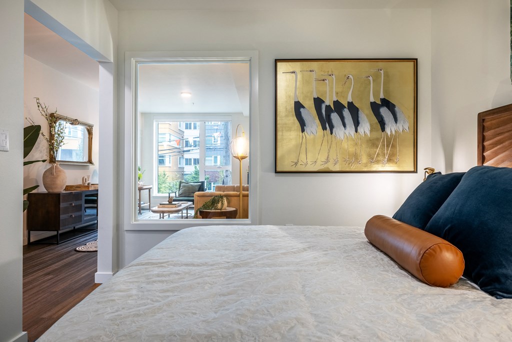 a bedroom with a large bed and a painting on the wall