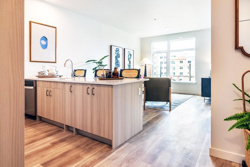 a kitchen with a counter and a living room with a window