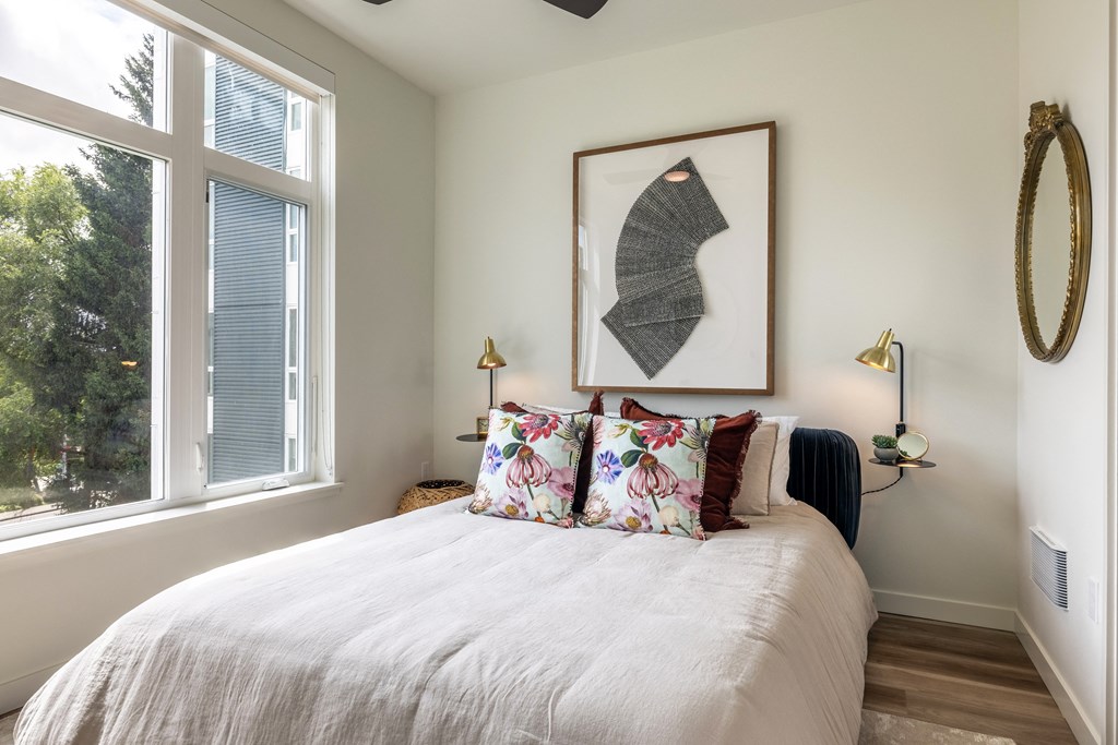 a bedroom with a bed and a large window