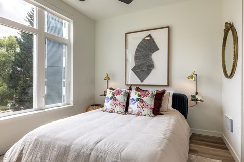 a bedroom with a bed and a large window