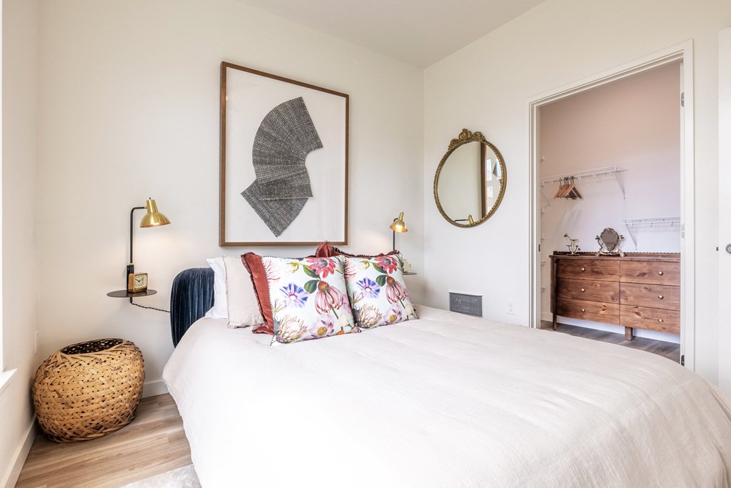 a bedroom with a bed and a dresser and a mirror