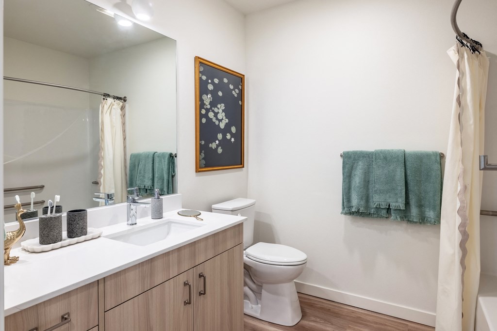 a bathroom with a toilet sink and shower and a mirror