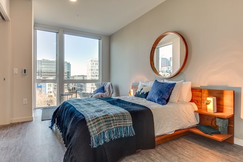 A bedroom with a large bed and a view of the city.