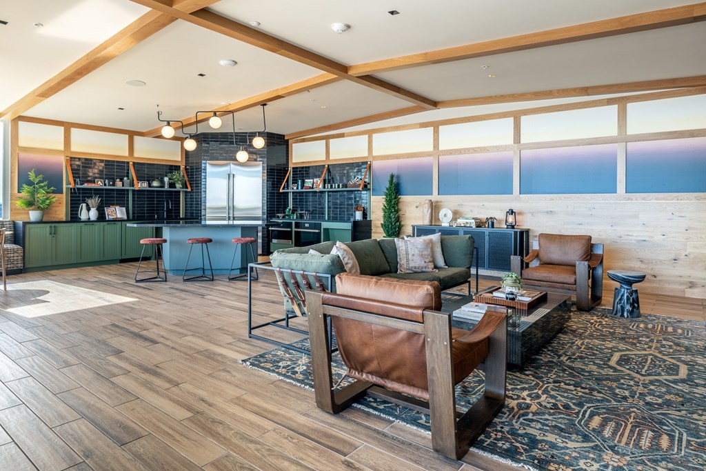 A living room with a brown leather couch and a rug.
