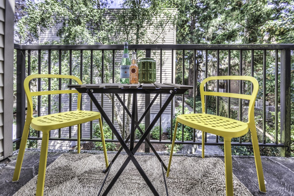 A table with two chairs and a bottle on it.