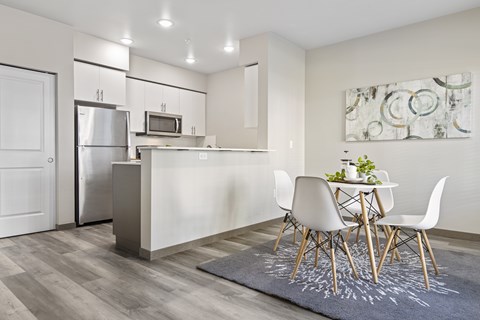 A modern kitchen with a dining table set for two.