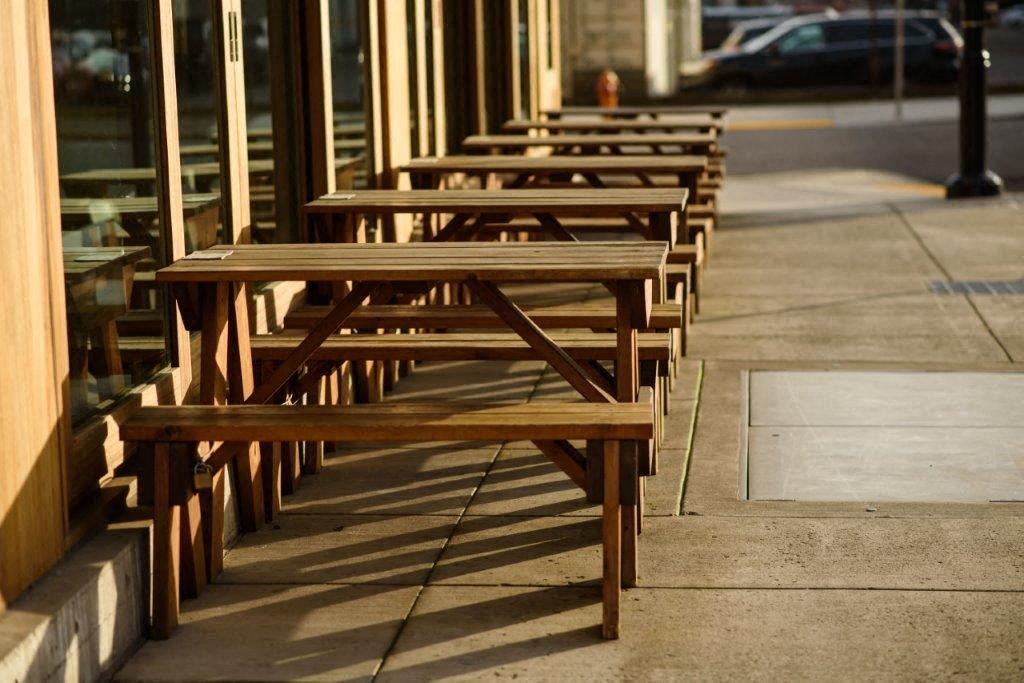 a row of wooden benches sitting on a sidewalk