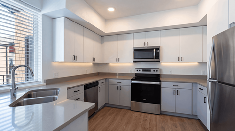 A modern kitchen with stainless steel appliances and white cabinets.