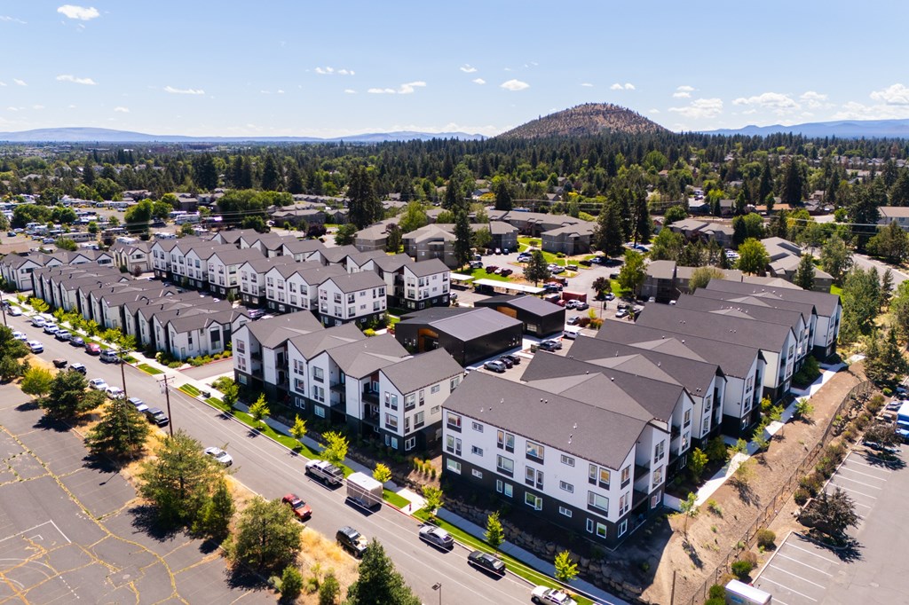 A large apartment complex with a parking lot in front.