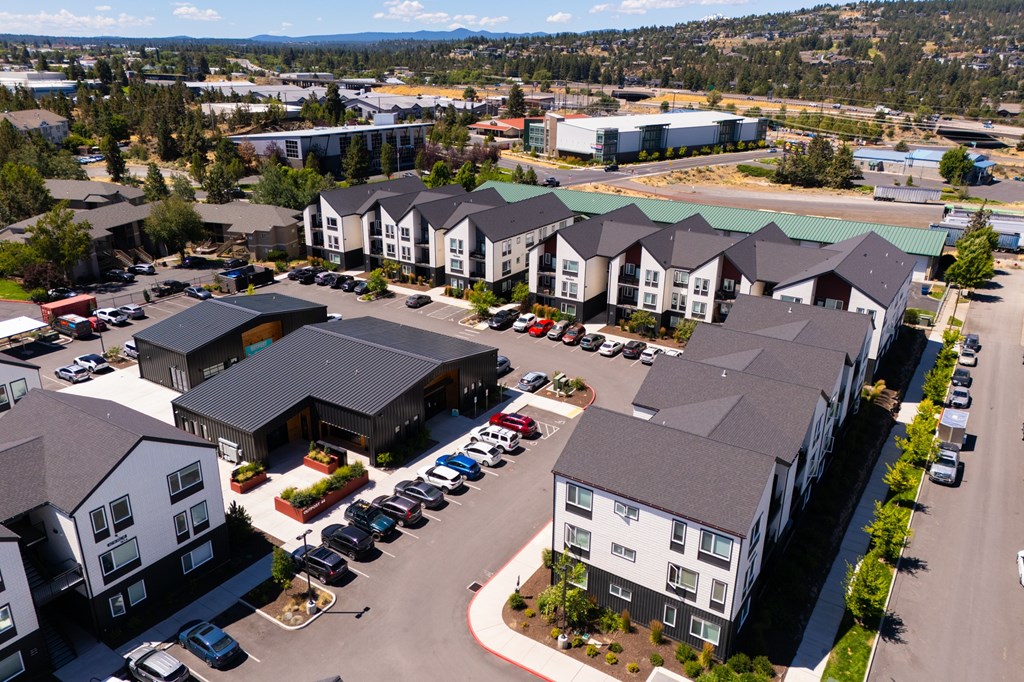 A large parking lot is surrounded by apartment buildings.