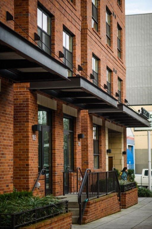 the front of a brick building with a balcony and stairs
