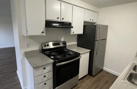A kitchen with black appliances and white cabinets.