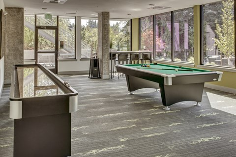 two pool tables in a room with large windows