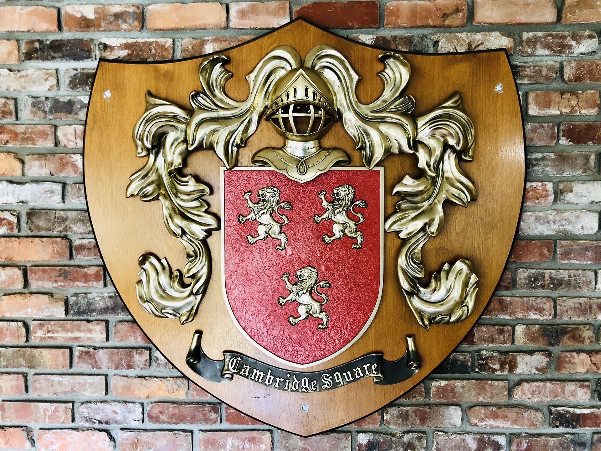 a red and gold shield on a brick wall