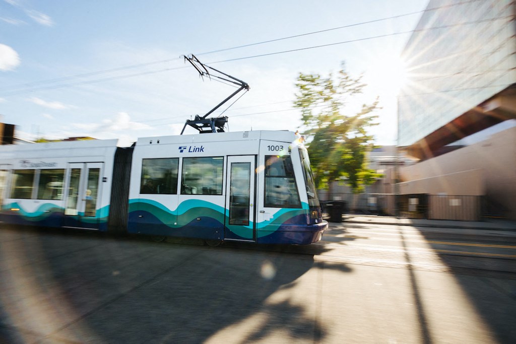 a white and blue tram on a city street