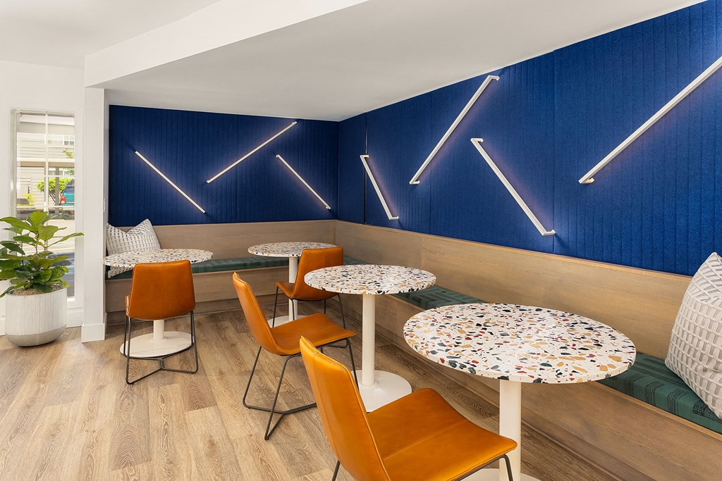 a restaurant with tables and chairs and a blue wall with lights