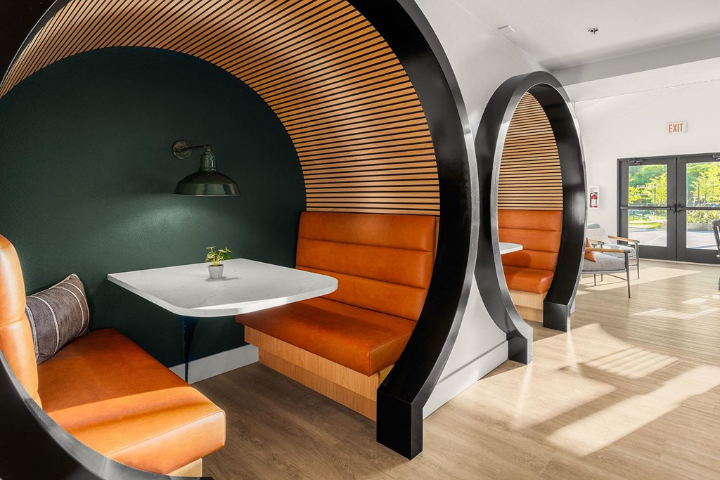 a meeting room with orange chairs and a white table