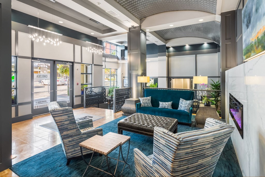 a lobby with couches chairs and tables and a fireplace