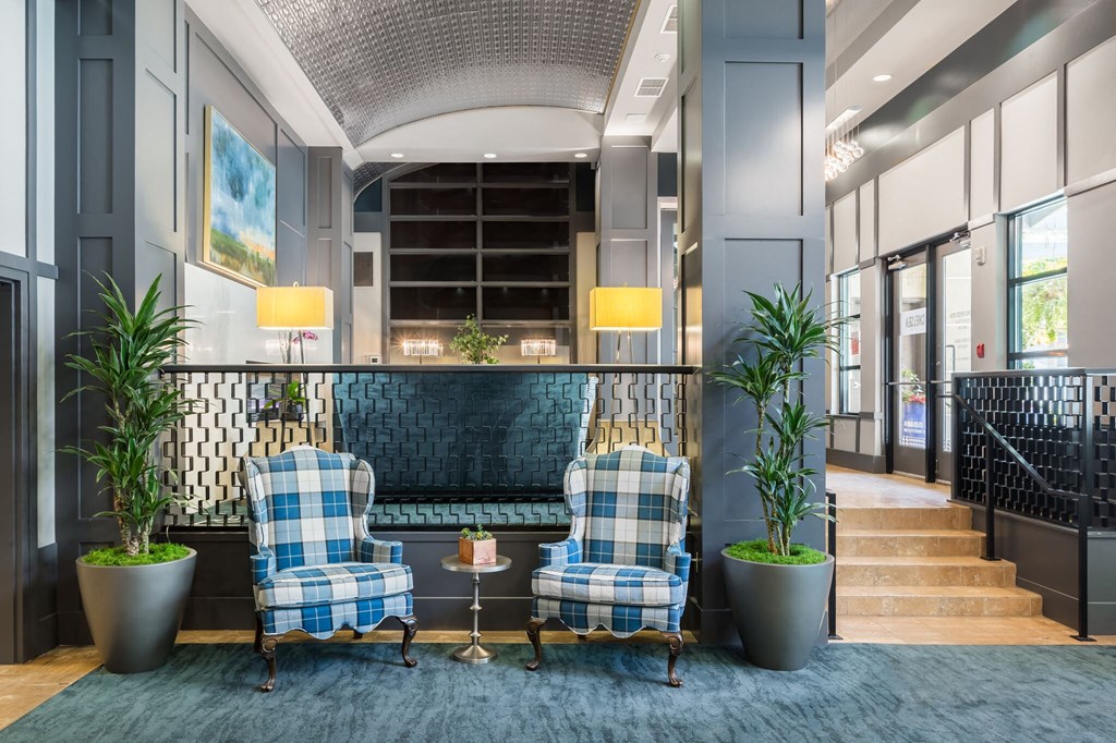 a lobby with two blue and white chairs and a blue rug