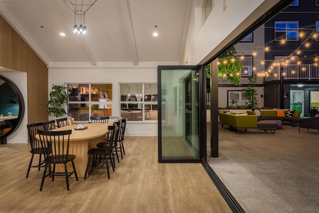 a dining area with a round table and glass doors
