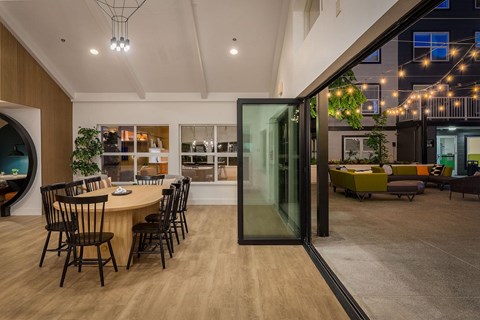 a dining area with a round table and glass doors