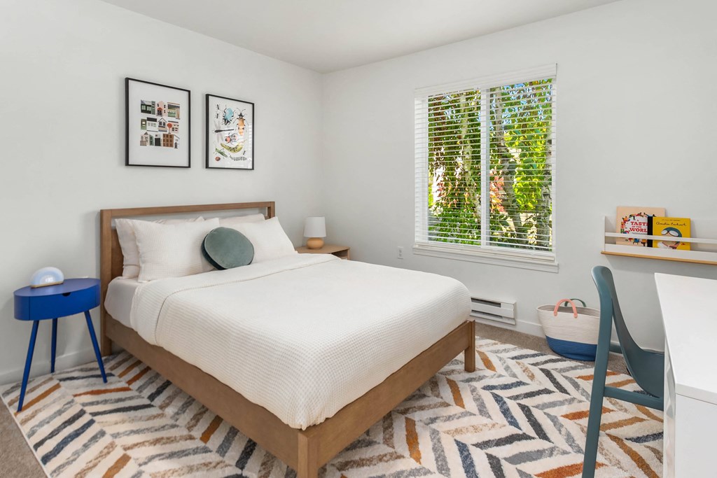 a bedroom with a bed and a desk and a window