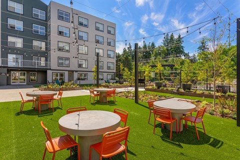 an outdoor patio with tables and chairs at an apartment complex