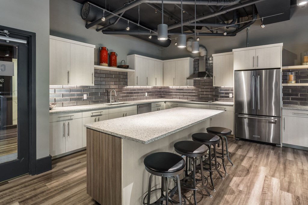 a kitchen with white cabinets and a marble counter top