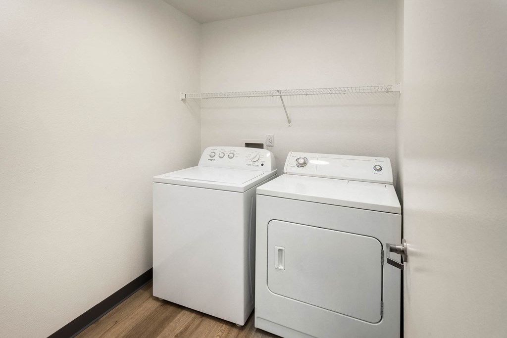 an empty laundry room with two washes and a dryer