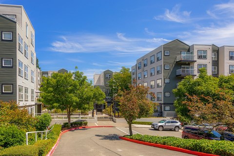 a view of an apartment complex with cars parked in a parking lot