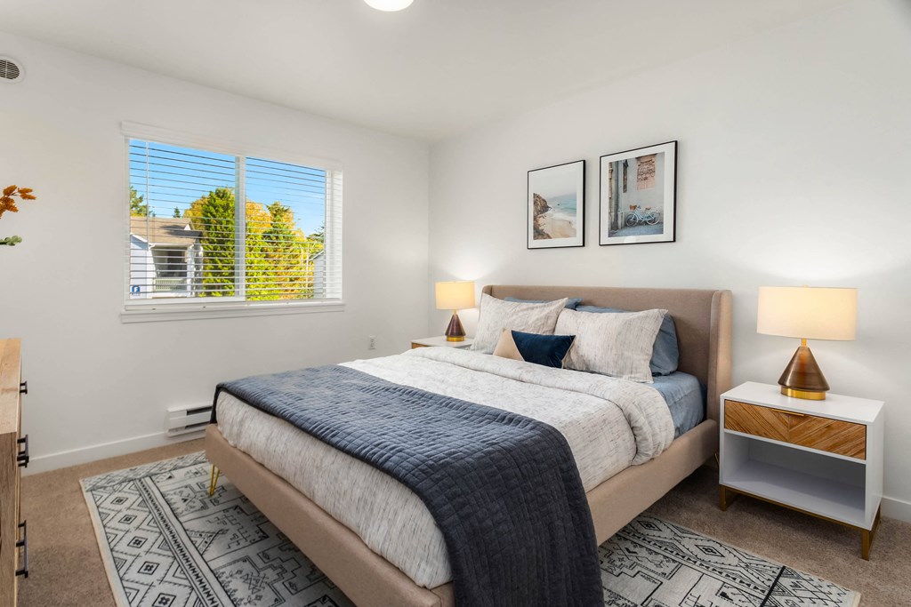 a bedroom with a bed and two windows