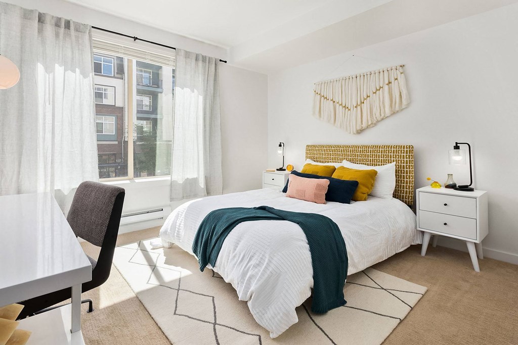 a bedroom with a bed and a large window