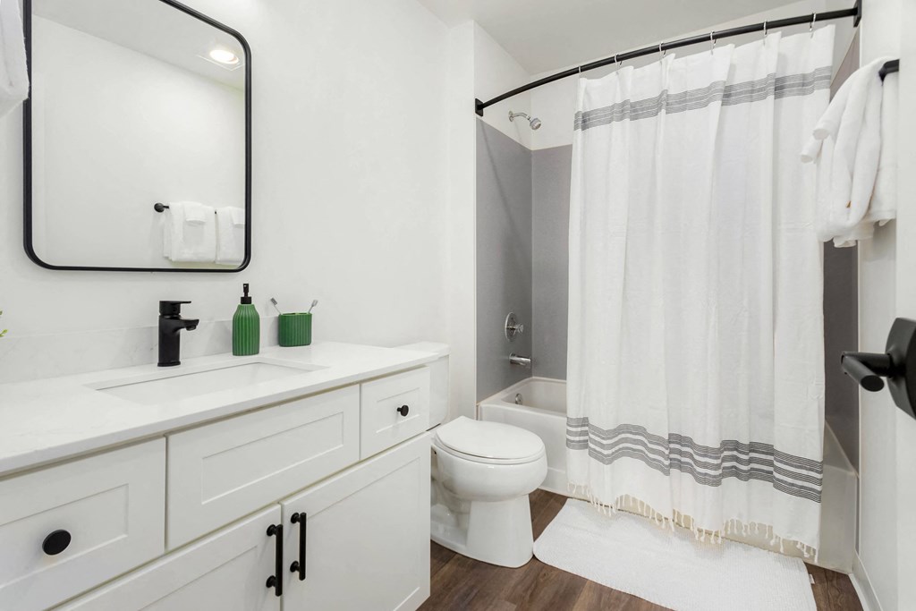 a white bathroom with a shower and a sink and a toilet