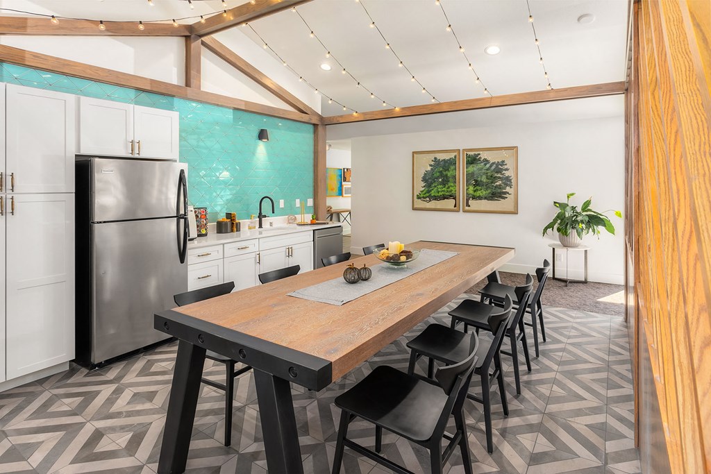 a kitchen with a large wooden table and a stainless steel refrigerator