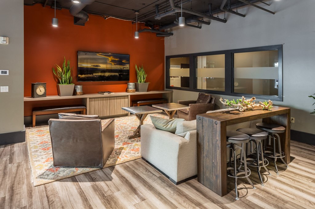 a living room with couches chairs and a bar with stools