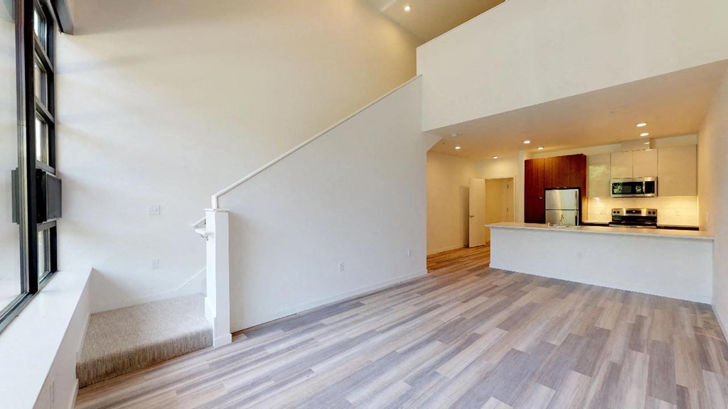the living room and kitchen of a house with a staircase