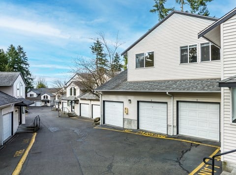 A row of houses with garages and driveways.