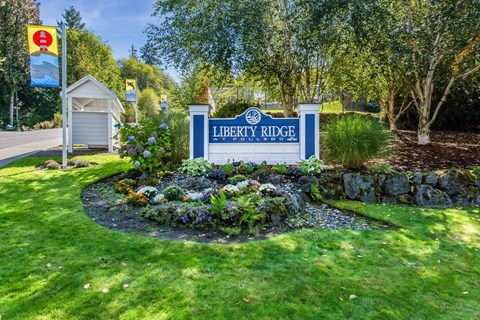 a sign for liberty ridge in front of a garden