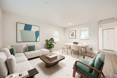A living room with a grey sofa, a green armchair, a wooden coffee table, and a painting on the wall.
