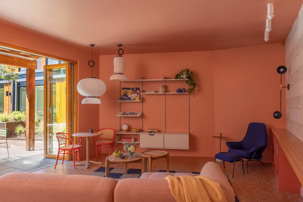 a living room with orange walls and a table and chairs
