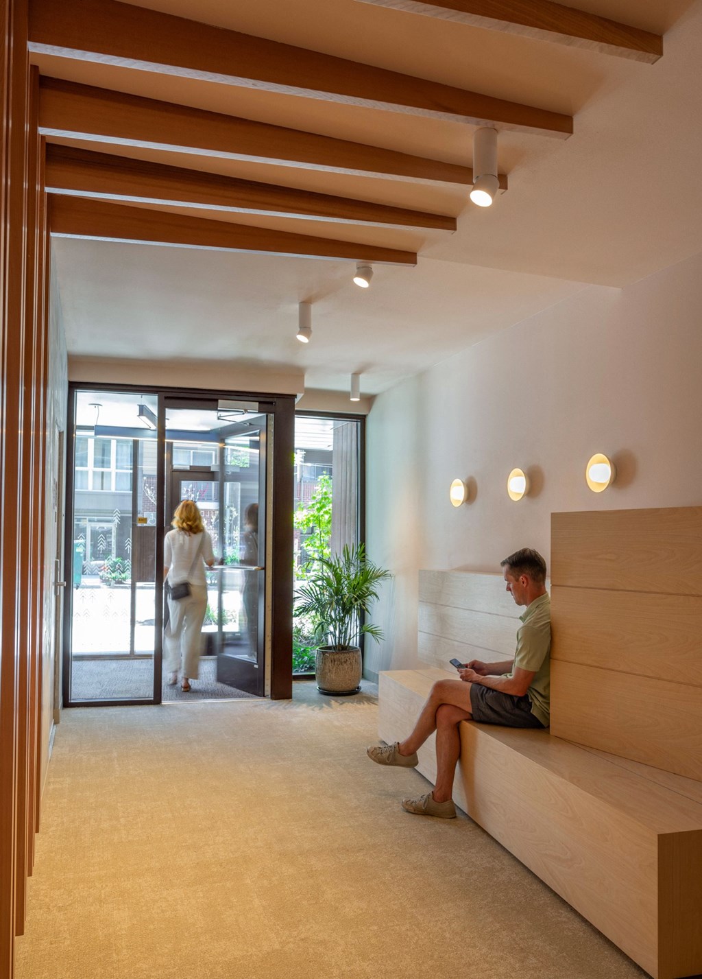 a woman sitting on a bench in a large lobby