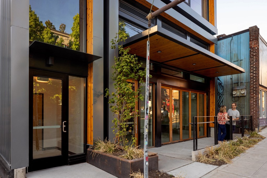the front entrance of a building with people walking out of it